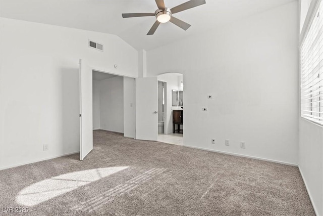 empty room featuring visible vents, light carpet, a ceiling fan, and vaulted ceiling