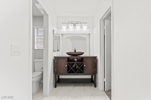 bathroom with vanity, toilet, and marble finish floor