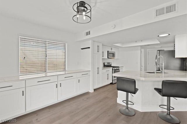 kitchen with visible vents, white cabinets, and appliances with stainless steel finishes