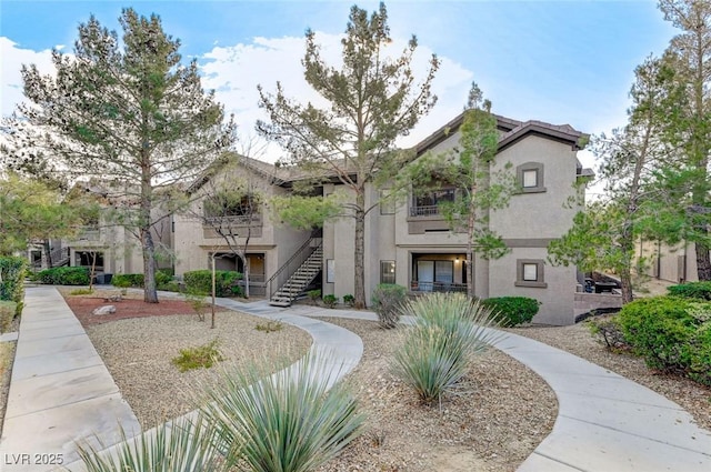 view of front of property featuring stairway and stucco siding