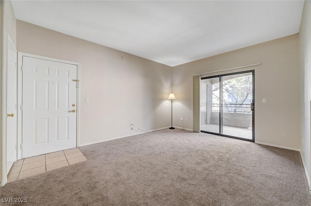 empty room featuring light carpet, baseboards, and light tile patterned flooring