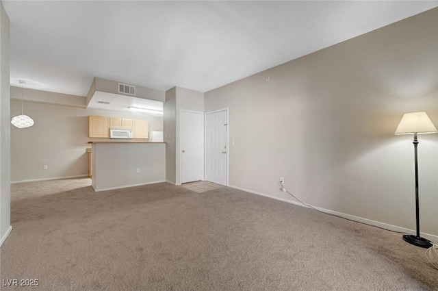 unfurnished living room with light carpet, visible vents, and baseboards