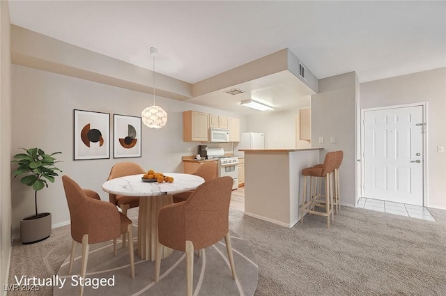 dining space featuring light carpet, visible vents, and baseboards