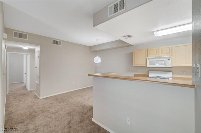 kitchen featuring pendant lighting, light countertops, visible vents, stove, and white microwave