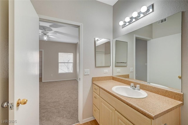 bathroom featuring baseboards, vanity, visible vents, and a ceiling fan