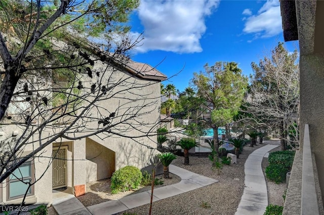 view of home's exterior with fence and stucco siding