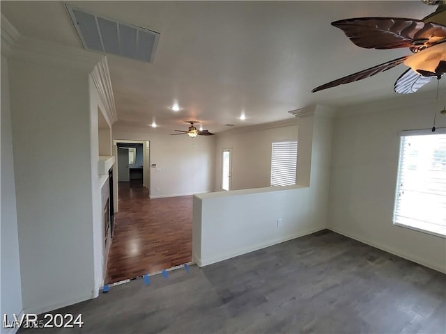 spare room with dark wood-style floors, visible vents, ornamental molding, ceiling fan, and baseboards