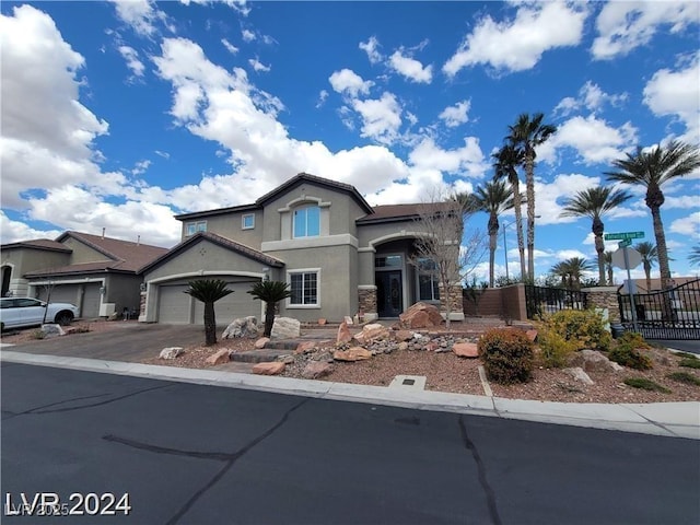 view of front of home with driveway, a garage, fence, and stucco siding