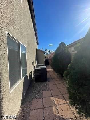 view of side of home featuring central AC, a patio, and stucco siding