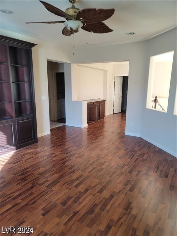 unfurnished living room with visible vents, dark wood finished floors, and baseboards