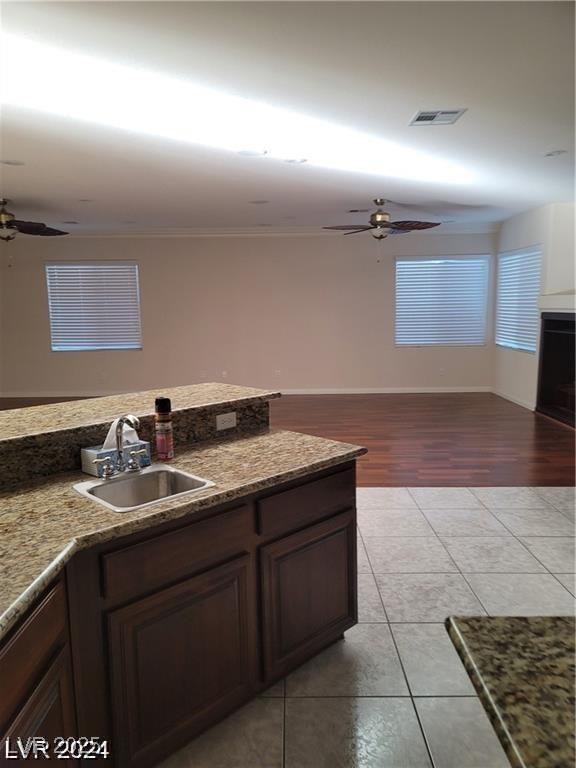 kitchen with ceiling fan, open floor plan, a sink, and visible vents