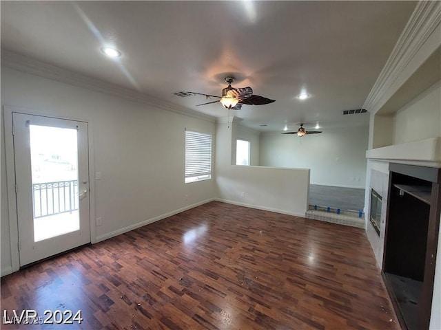 unfurnished living room featuring baseboards, visible vents, dark wood-type flooring, crown molding, and a fireplace