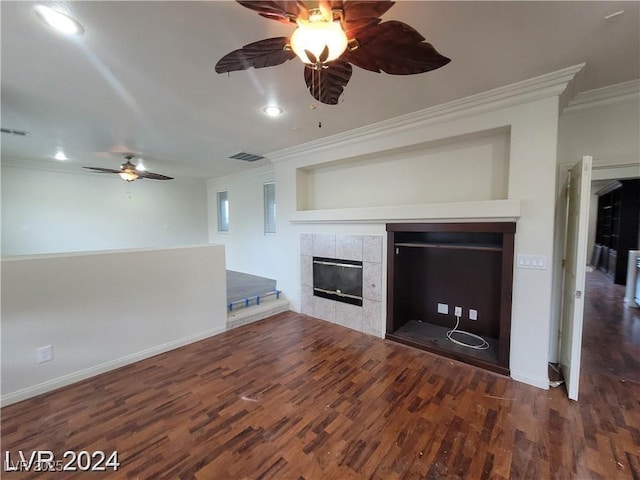 unfurnished living room featuring baseboards, visible vents, dark wood finished floors, ornamental molding, and a fireplace