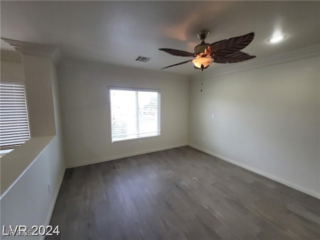 empty room featuring a ceiling fan, baseboards, visible vents, and dark wood-type flooring