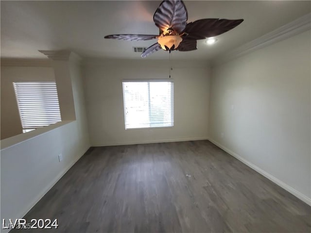 spare room featuring ceiling fan, baseboards, dark wood-type flooring, and ornamental molding