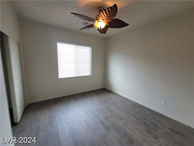 spare room with dark wood-style floors and a ceiling fan