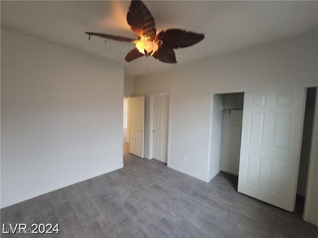 unfurnished bedroom featuring ceiling fan and dark wood-style flooring