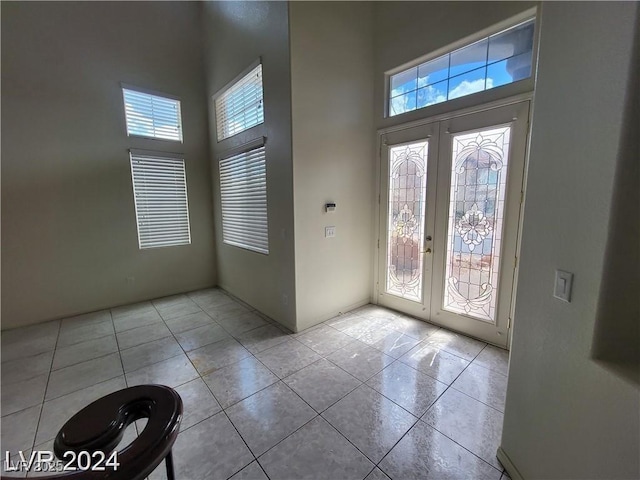 interior space with plenty of natural light, light tile patterned flooring, and french doors