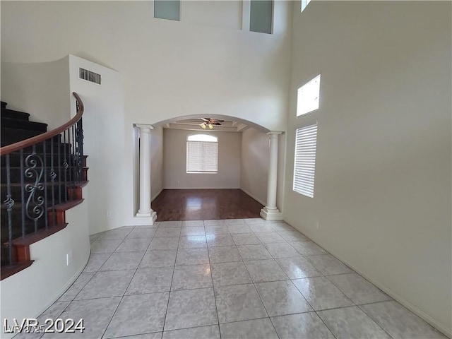 entrance foyer featuring decorative columns, visible vents, arched walkways, and a wealth of natural light