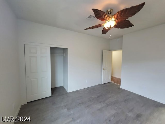 unfurnished bedroom with a ceiling fan, a closet, visible vents, and dark wood-style flooring