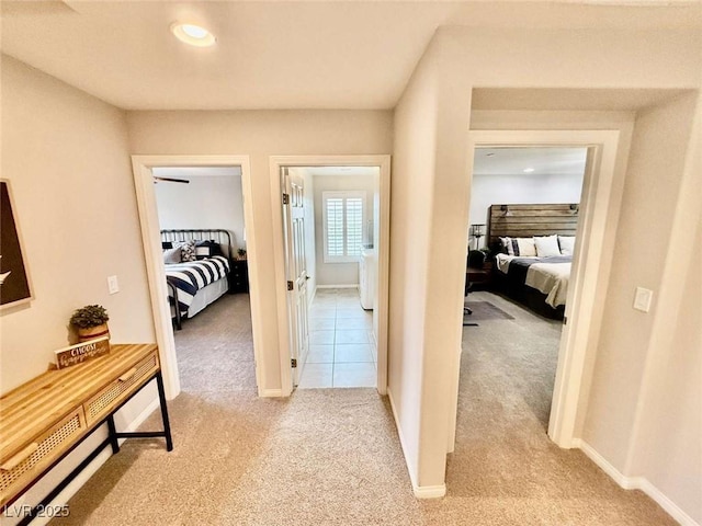 hall featuring light carpet and baseboards