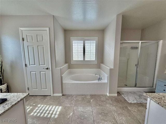 full bath with baseboards, a garden tub, vanity, and a shower stall