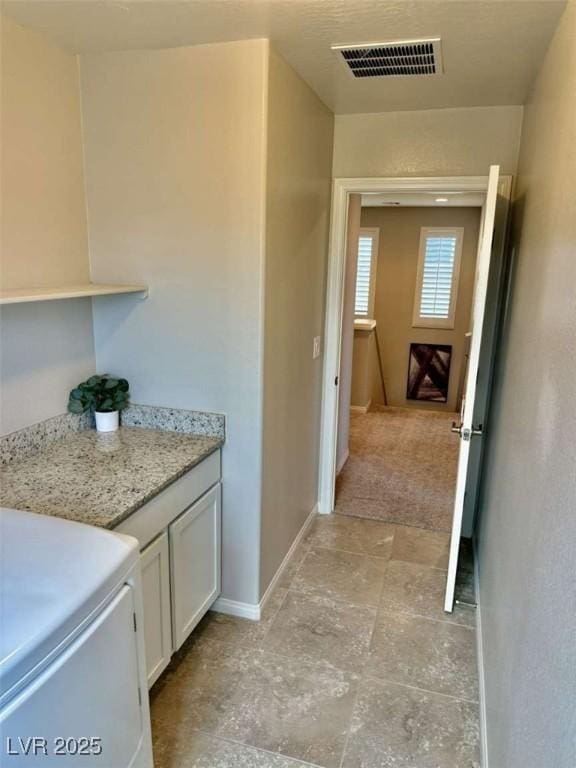 interior space with washer / dryer, baseboards, and visible vents