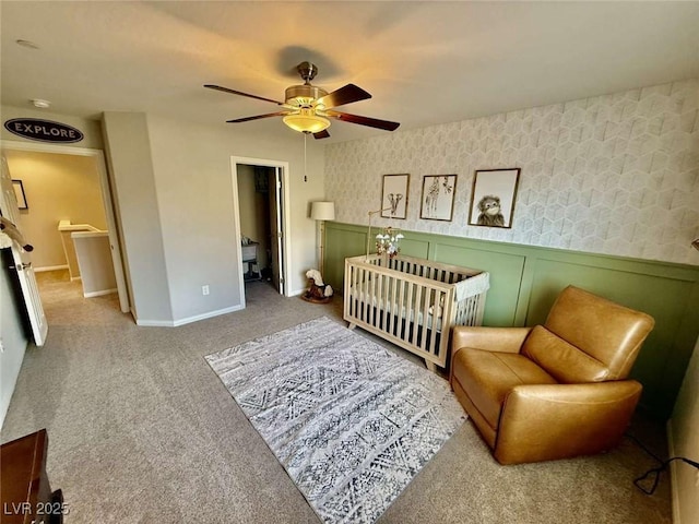 bedroom featuring carpet, ceiling fan, wainscoting, and wallpapered walls