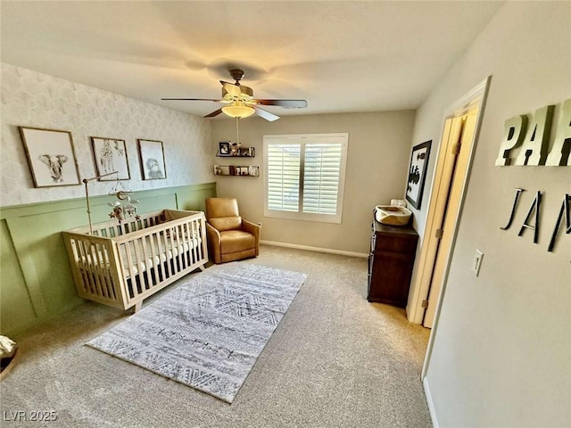 bedroom featuring a ceiling fan, light carpet, baseboards, and wallpapered walls