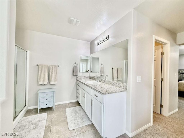 bathroom featuring connected bathroom, visible vents, vanity, baseboards, and a stall shower