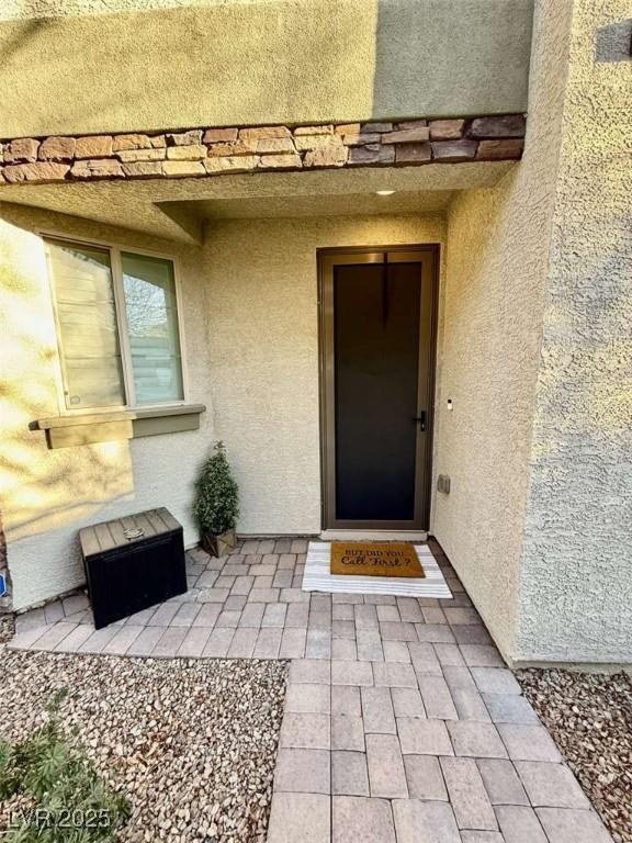 entrance to property featuring stucco siding