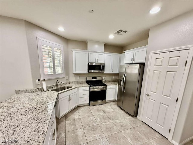 kitchen with appliances with stainless steel finishes, visible vents, and white cabinets