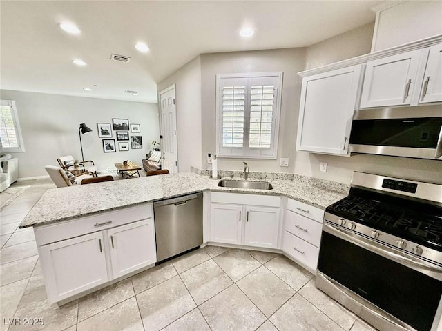 kitchen featuring appliances with stainless steel finishes, white cabinetry, a sink, and visible vents