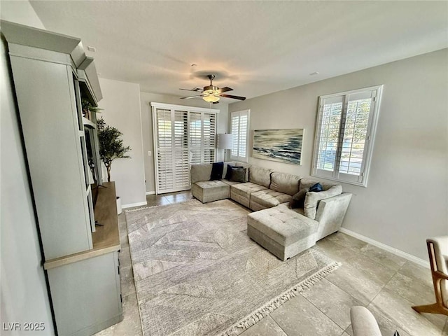 living area with plenty of natural light, baseboards, and ceiling fan