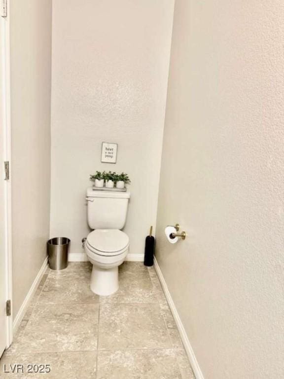 bathroom with toilet and baseboards