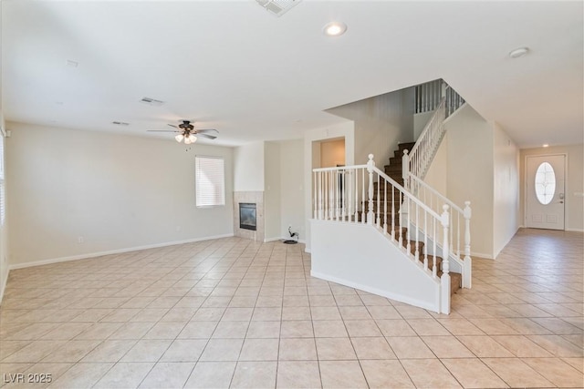 interior space featuring a ceiling fan, a wealth of natural light, light tile patterned flooring, and stairway