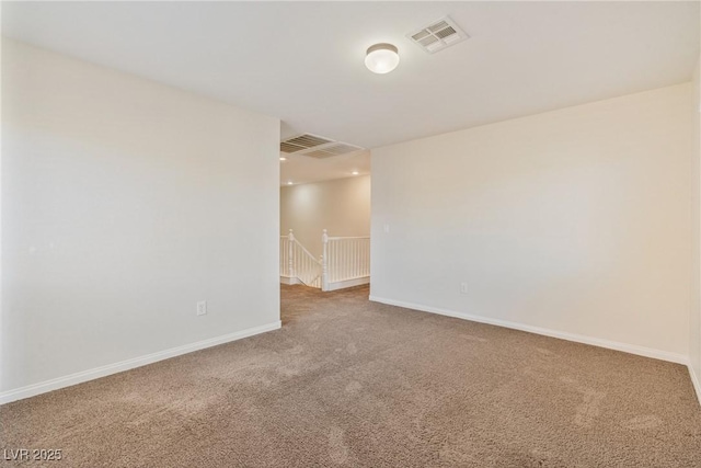 carpeted empty room featuring baseboards and visible vents