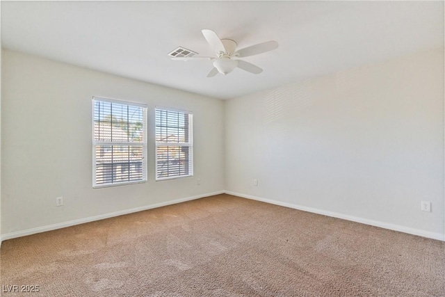 unfurnished room with baseboards, carpet, visible vents, and a ceiling fan