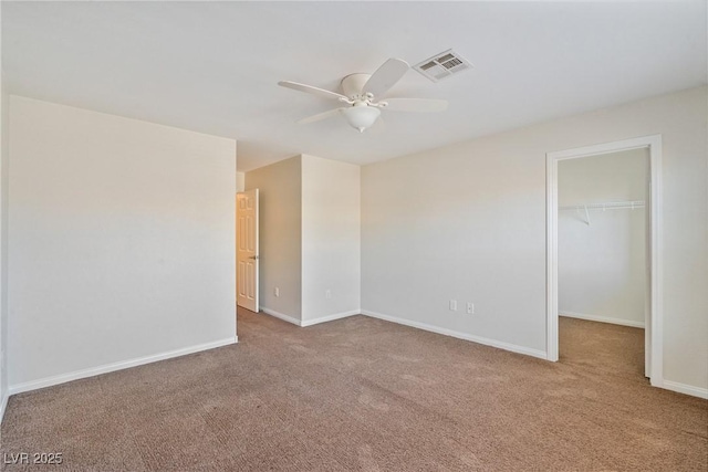 carpeted empty room featuring a ceiling fan, visible vents, and baseboards