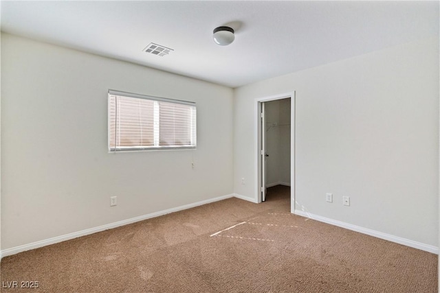 carpeted spare room featuring visible vents and baseboards