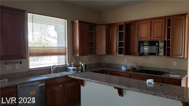 kitchen with brown cabinets, open shelves, a sink, dark stone counters, and black appliances