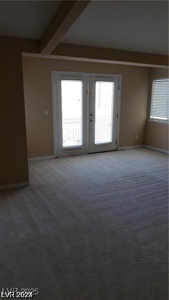 spare room with carpet flooring, beamed ceiling, and baseboards