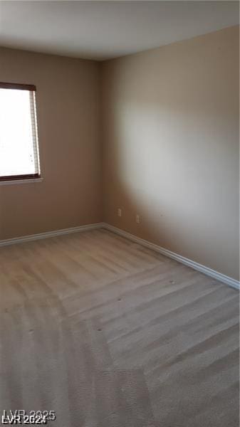 empty room featuring carpet flooring and baseboards