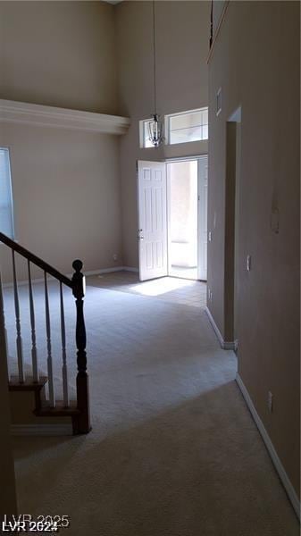 foyer with stairs, carpet, and baseboards