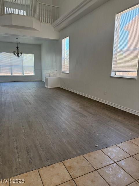 4798 Luna Ridge Ct, Las Vegas, NV 89129 - spare room with a chandelier, a towering ceiling, tile patterned flooring, plenty of natural light, and baseboards