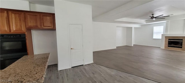 4798 Luna Ridge Ct, Las Vegas, NV 89129 - unfurnished living room with a fireplace with flush hearth, wood finished floors, ceiling fan, and baseboards