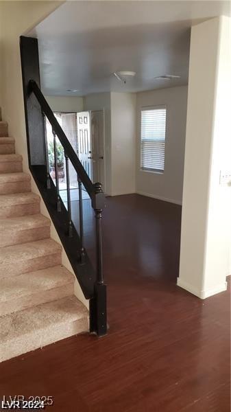 stairway with wood finished floors and baseboards