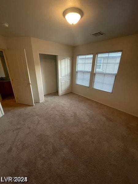 unfurnished bedroom featuring a closet, visible vents, and carpet flooring