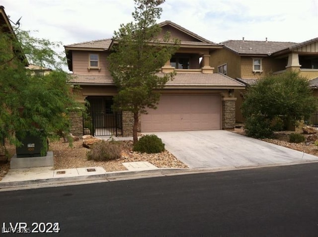 view of front of home featuring a garage, stone siding, and concrete driveway