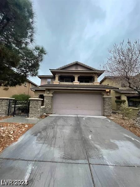 view of front of house featuring a garage, stone siding, fence, and driveway